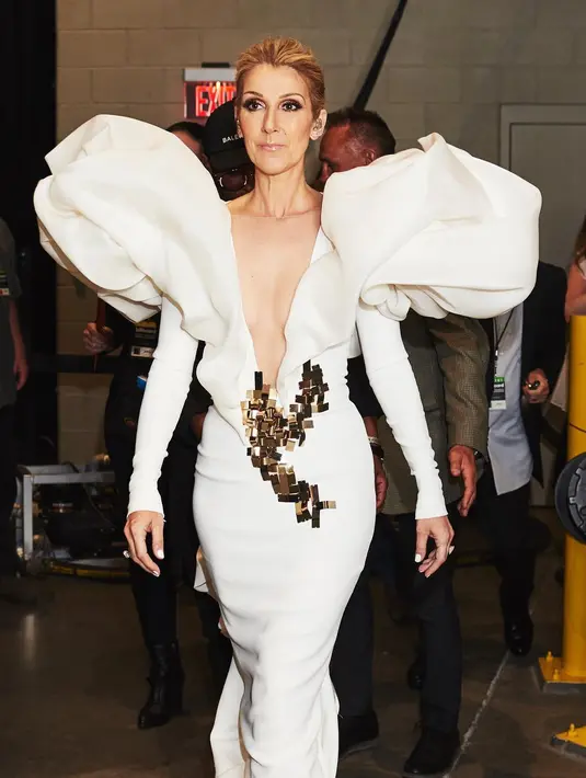 Celine Dion selalu menghadirkan gaya yang tak biasa. Pesona diva Celine Dion juga terlihat dari pemilihan outfitnya yang mengagumkan, seperti dress dengan detail baju yang besar dan garis leher V yang dalam. Foto: Instagram.