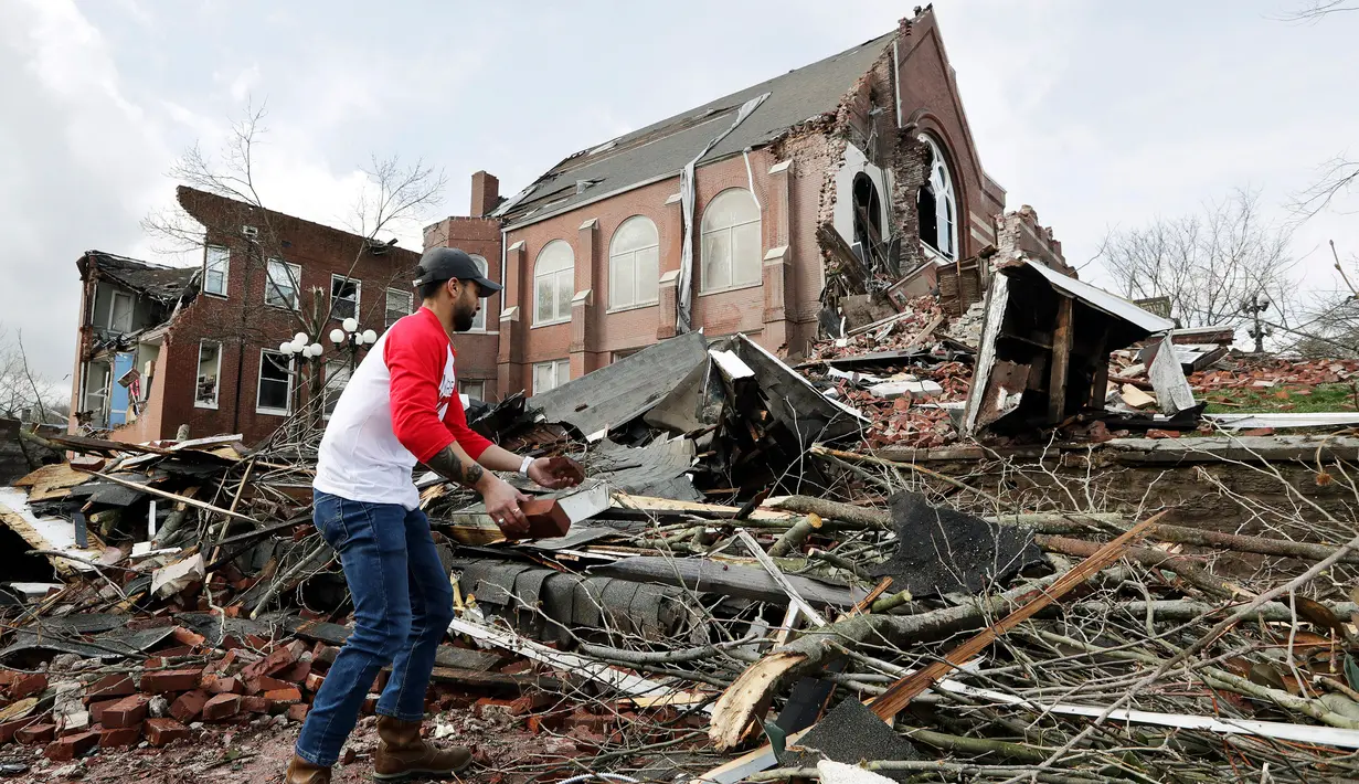 Sumant Joshi membantu membersihkan puing-puing Gereja East United Methodist setelah rusak parah akibat tornado menerjang Nashville, Tennessee, Amerika Serikat, Selasa (3/3/2020). Terjangan tornado menyebabkan kerusakan besar pada bangunan, jalan, jembatan, dan pusat bisnis. (AP Photo/Mark Humphrey)