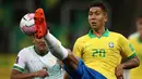 Penyerang Brasil, Roberto Firmino, berebut bola dengan bek Bolivia, Gabriel Valverde, pada laga kualifikasi Piala Dunia 2020 di Corinthians Arena, Sabtu (10/10/2020) pagi WIB. Brasil menang 5-0 atas Bolivia. (AFP/Buda Mendes/pool)