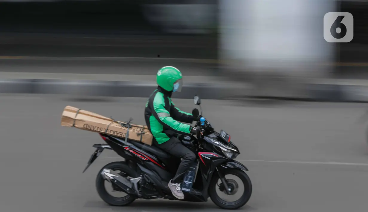 Pengemudi ojek online membawa barang pesanan di kawasan Harmoni, Jakarta, Selasa (7/4/2020). Hal tersebut berdasarkan Permenkes Nomor 9 Tahun 2020 tentang Pedoman PSBB dalam Penanganan COVID-19. (Liputan6.com/Faizal Fanani)