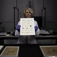 Konservator Israel Antiquities Authority Tanya Bitler menunjukkan fragmen Gulungan Laut Mati baru yang ditemukan di Yerusalem, Selasa (16/3/2021). Arkeolog Israel mengumumkan penemuan puluhan potongan Gulungan Naskah Laut Mati (Dead Sea Scroll) baru yang memuat teks alkitab. (AP/Sebastian Scheiner)