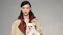 Seorang model menggendong anak anjing saat memamerkan rancangan Tod's di Milan Fashion Week, Milan, Italia, Jumat (23/2). Selain Gigi Hadid, para model Tod's lainnya juga membawa anak anjing saat tampil di Milan Fashion Week. (Filippo MONTEFORTE/AFP)