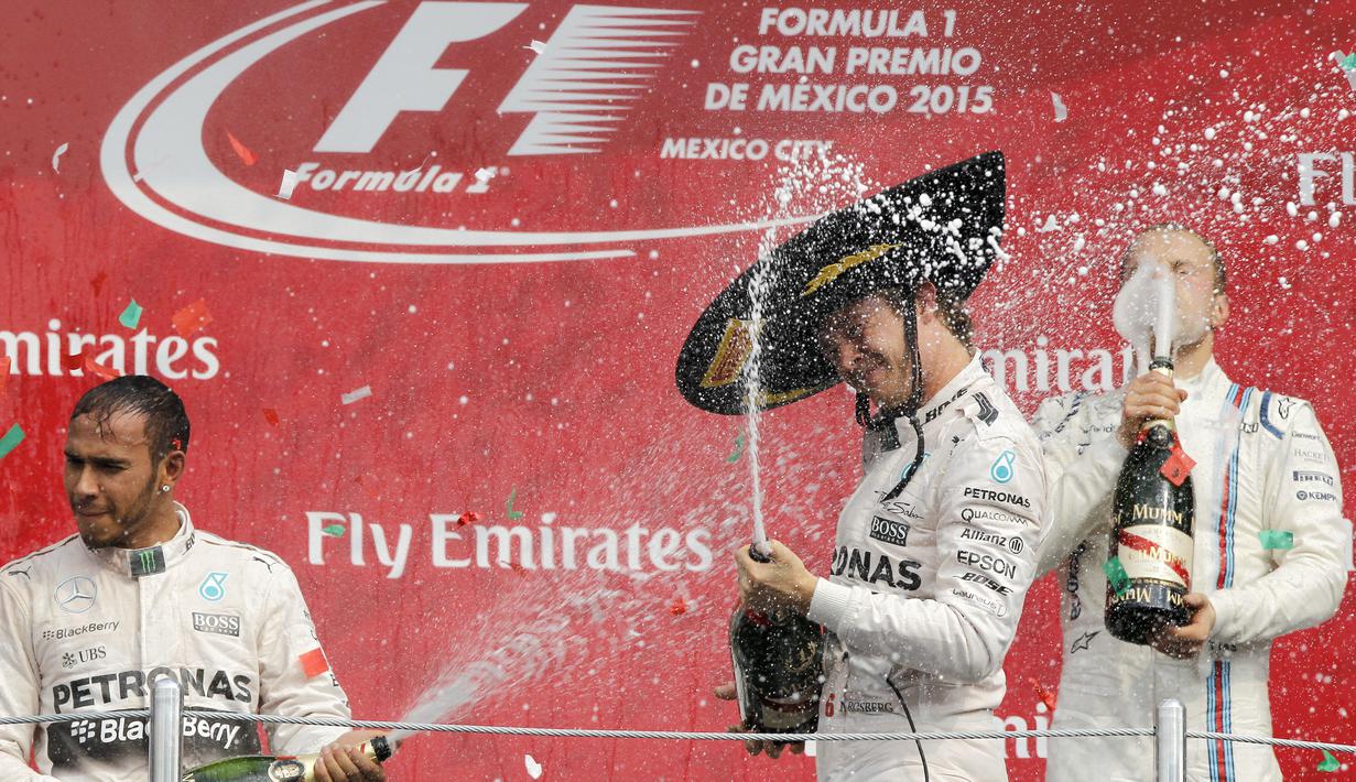 Dua pebalap Mercedes saling semprotkan sampanye di podium juara F1 GP Meksiko di Sirkuit Autodromo Hermanos Rodriguez, Senin (2/11/2015) dini hari WIB. (EPA/Ulises Ruiz Basurto)