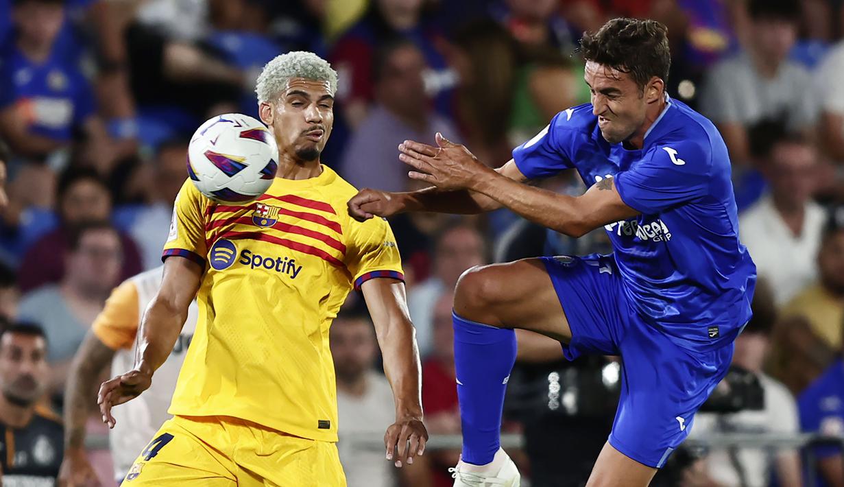 Pemain Barcelona, Ronald Araujo (kiri) berebut bola dengan pemain Getafe, Juanmi Latasa pada laga pekan pertama Liga Spanyol 2023/2024 di Coliseum Alfonso Perez Stadium, Getafe, Spanyol, 14 Agustus 2023 WIB. (AP Photo/Alvaro Medranda)