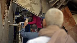 Orang-orang berkumpul di sekitar reruntuhan dua kereta yang bertabrakan di distrik Tahta di provinsi Sohag, sekitar 460 km (285 mil) selatan ibu kota Mesir, Kairo (26/3/2021). Mesir telah dilanda kecelakaan kereta api yang mematikan dalam beberapa tahun terakhir. (AFP)