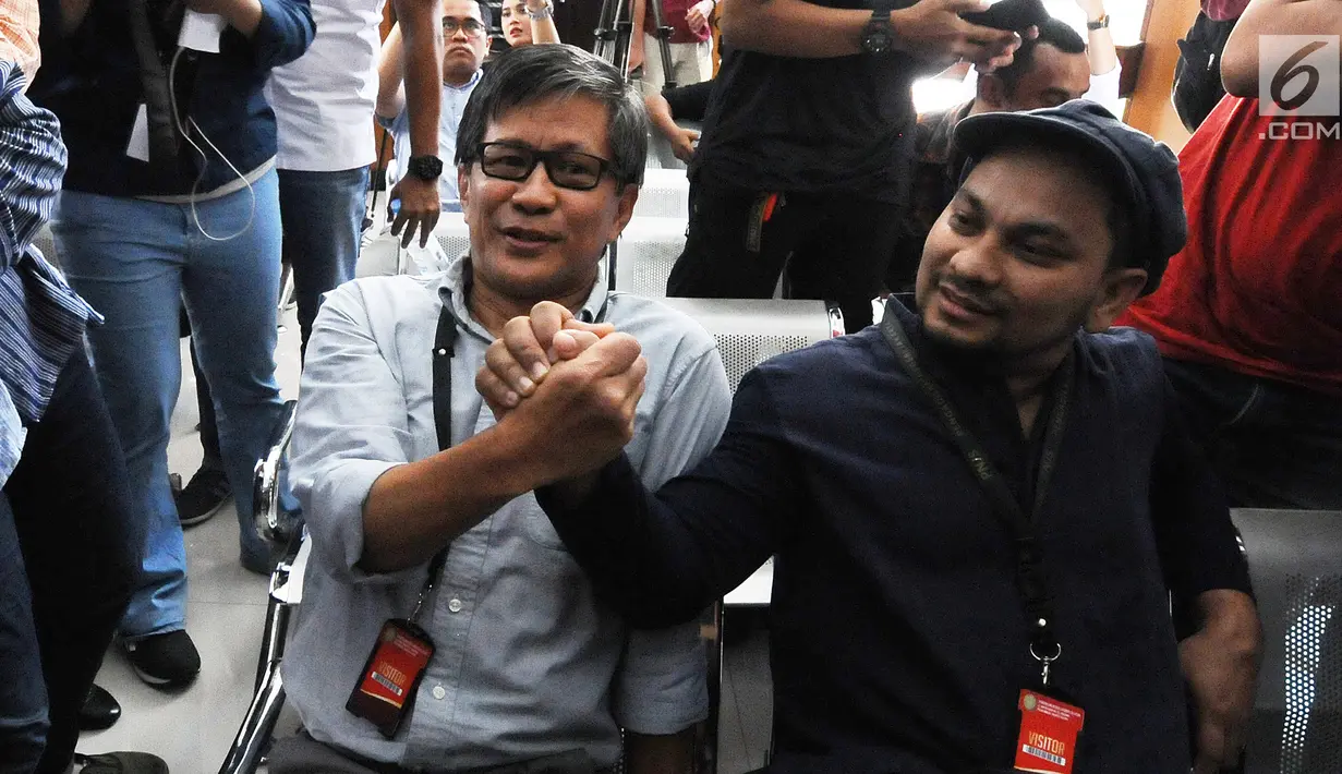 Penyanyi Tompi dan Akademisi Rocky Gerung berjabat tangan sebelum menjalani sidang lanjutan sebagai saksi kasus berita bohong Ratna Sarumpaet di PN Jakarta Selatan, Selasa (23/4). (Liputan6.com/Herman Zakharia)