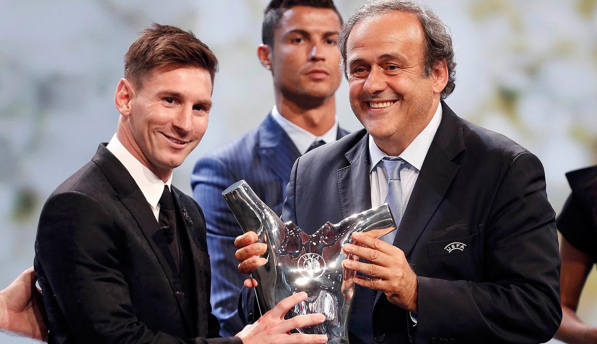 Lionel Messi menerima piala penghargaan sebagai pemain terbaik Eropa 2014-2015 dari Presiden UEFA Michel Platini di Monte Carlo, Kamis (27/8/2015). Pemain Argentina ini menyisihkan Cristiano Ronaldo dan Luis Suarez. (REUTERS/Eric Gaillard)