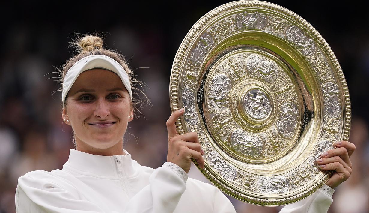 Selebrasi petenis tunggal putri Republik Ceska, Marketa Vondrousova dengan trofi juara setelah mengalahkan petenis Tunisia, Ons Jabeur pada laga final turnamen tenis Wimbledon 2023 di All England Lawn and Tennis Club, London, Sabtu (16/7/2023) malam WIB. (AP Photo/Alberto Pezzali)