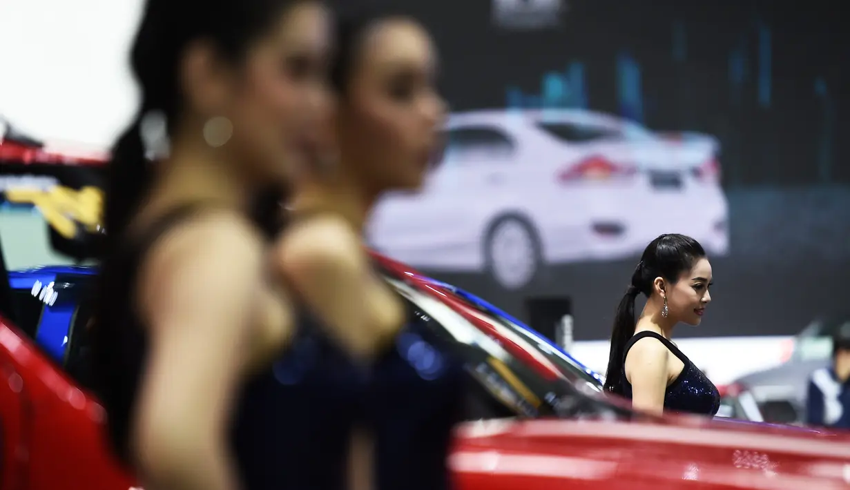 Sejumlah model berpose di samping mobil selama Thailand International Motor Expo di Bangkok (29/11). (AFP Photo/Lillian Suwanrumpha)