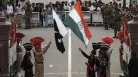 Tentara Pakistan (berseragam hitam) dan India dalam upacara rutin penurunan bendera di perbatasan (Reutes)