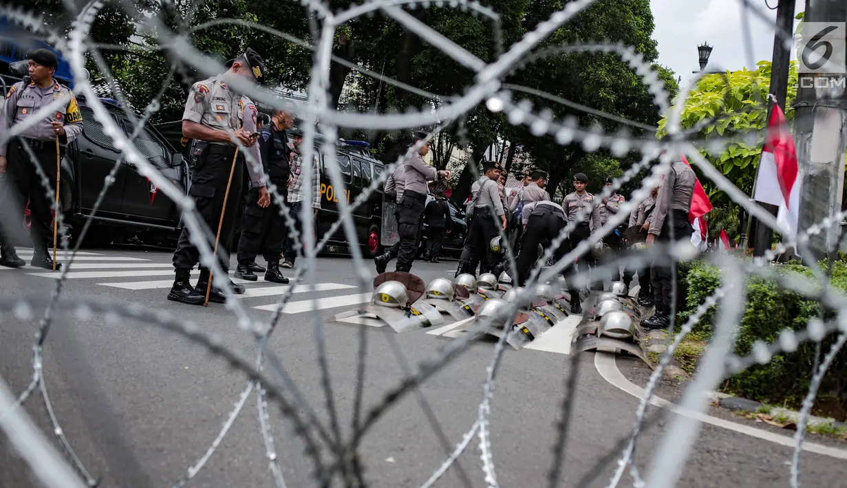 Helm dan tameng aparat kepolisian di area gedung KPU Jakarta, Jumat (1/3). Sebanyak 4.039 personel gabungan TNI, polisi dan Pemprov DKI disiagakan dalam mengamankan aksi massa Forum Umat Islam (FUI) dan Gerakan Jaga Indonesia. (Liputan6.com/Faizal Fanani)