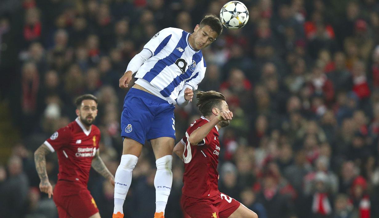 Pemain FC Porto, Diogo Dalot (tengah) menyundul bola melewati pemain Liverpool, Adam Lallana pada leg kedua Liga Champions di Anfield Stadium, Liverpool, (6/3/2018). Liverpool bermain imbang 0-0. (AP/Dave Thompson)