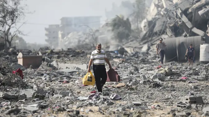 Kehancuran terlihat jelas di seluruh Gaza, ketika warga Palestina mati-matian mencari korban yang selamat dan terpaksa berjalan melewati puing-puing yang tertinggal setelah pemboman Israel. (AP Photo/Ali Mahmoud)