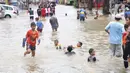 Anak-anak bermain di genangan air yang membanjiri Jalan KH Hasyim Ashari, Tangerang, Banten, Kamis (2/1/2020). Banjir yang menggenangi jalan penghubung Jakarta- Tangerang tersebut mulai surut dan sudah bisa dilintasi pejalan kaki. (Liputan6.com/Angga Yuniar)