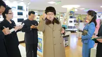 Kim Jong-un tampak menyampaikan sesuatu kepada sejumlah stafnya saat melakukan kunjungan dan keliling ke pusat perbelanjaan Mirae Shop yang baru dibangun di kompleks Mirae Shop di Korea Utara (28/3). (REUTERS/KCNA)