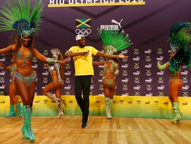 Pelari asal Jamaika, Usain Bolt saat menari samba bersama penari saat konferensi pers cabang atletik Olimpiade Rio 2016 di Rio de Janeiro, Brasil, (8/8). Bolt adalah pemegang rekor dunia lari 100m dan 200m putra saat ini. (REUTERS/Nacho Doce)