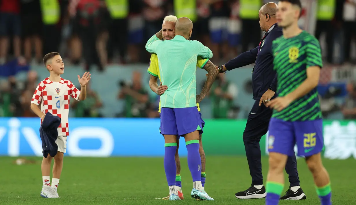 Gelandang Kroasia #04 Putra gelandang Kroasia, Ivan Perisic (kiri) memberi isyarat penyerang Brasil #10 Neymar (Tengah) dihibur oleh bek Brasil #13 Dani Alves setelah kalah pada perempat final Piala Dunia 2022 di Stadion Education City, Sabtu (10/12/2022) dini hari WIB. (Photo by Adrian DENNIS / AFP)