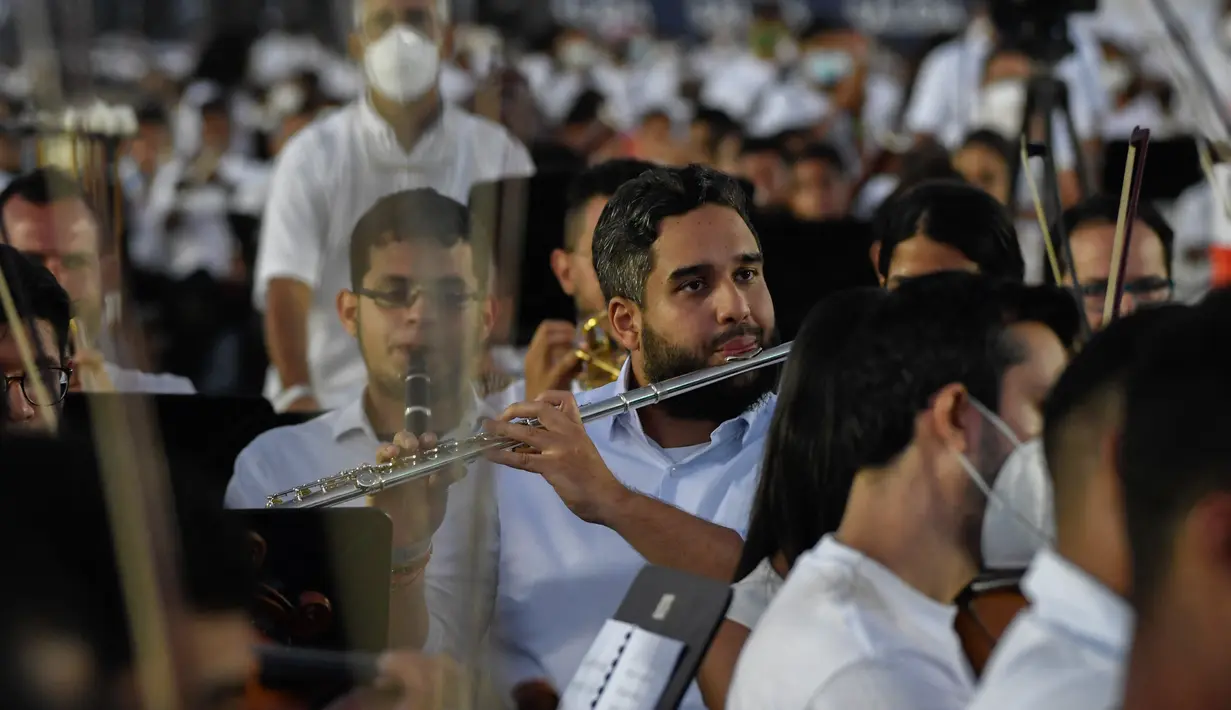Wakil Majelis Nasional Venezuela, Nicolas Ernesto Maduro Guerra (tengah), putra Presiden Nicolas Maduro memainkan serulingnya saat berusaha memecahkan rekor dunia bermain orkestra terbesar di dunia, dengan lebih dari 12.000 musisi, di Caracas pada 13 November 2021. Federico PARRA/AFP)