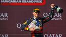 Pembalap Red Bull Racing, Max Verstappen berjalan meninggalkan podium sambil membawa trofinya yang pecah pada Formula 1 GP Hungaria di Sirkuit Hungaroring, Mogyorod, Hungaria, Minggu (23/07/2023). (AP Photo/Denes Erdos)