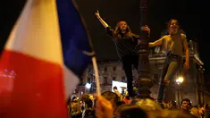 Dua orang wanita Prancis menari di lampu jalan museum Louvre, tempat Emmanuel Macron menyampaikan pidato kemenangannya, di Paris, Minggu (7/5). Emmanuel Macron mendapatkan suara tertinggi pada pemilihan presiden putaran kedua. (AP Photo/Laurent Cipriani)