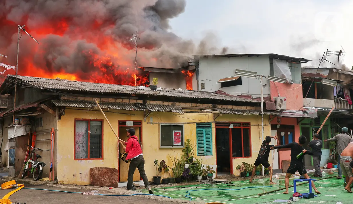Warga berusaha memadamkan api saat terjadi kebakaran di kawasan padat penduduk di Jalan Simprug Golf II RT 4/8, Grogol Selatan, Kebayoran Lama, Jakarta Selatan, Minggu (21/8/2022). Belum diketahui penyebab kebakaran yang membakar puluhan rumah tersebut. (Liputan6.com/Angga Yuniar)