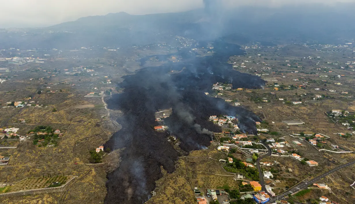 Lava dari letusan gunung berapi Cumbre Vieja mengalir menghancurkan rumah-rumah di pulau La Palma di Kepulauan Canary, Spanyol, Selasa (21/9/2021). Lava yang mengalir dari letusan gunung berapi itu memaksa evakuasi sekitar 5.500 orang dan menghancurkan sedikitnya 100 rumah. (AP/Emilio Morenatti)