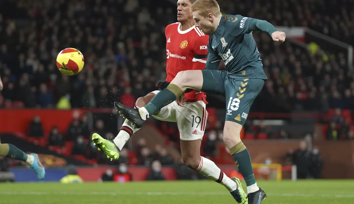 Pemain Middlesbrough, Duncan Watmore berusaha mengumpan bola dari kawalan bek Manchester United, Raphael Varane pada putaran keempat Piala FA 2021/2022 di stadion Old Trafford di Manchester, Inggris, Sabtu (5/2/2022). MU kalah lewat adu penalti 7-8 dari Middlesbrough. (AP Photo/Jon Super)