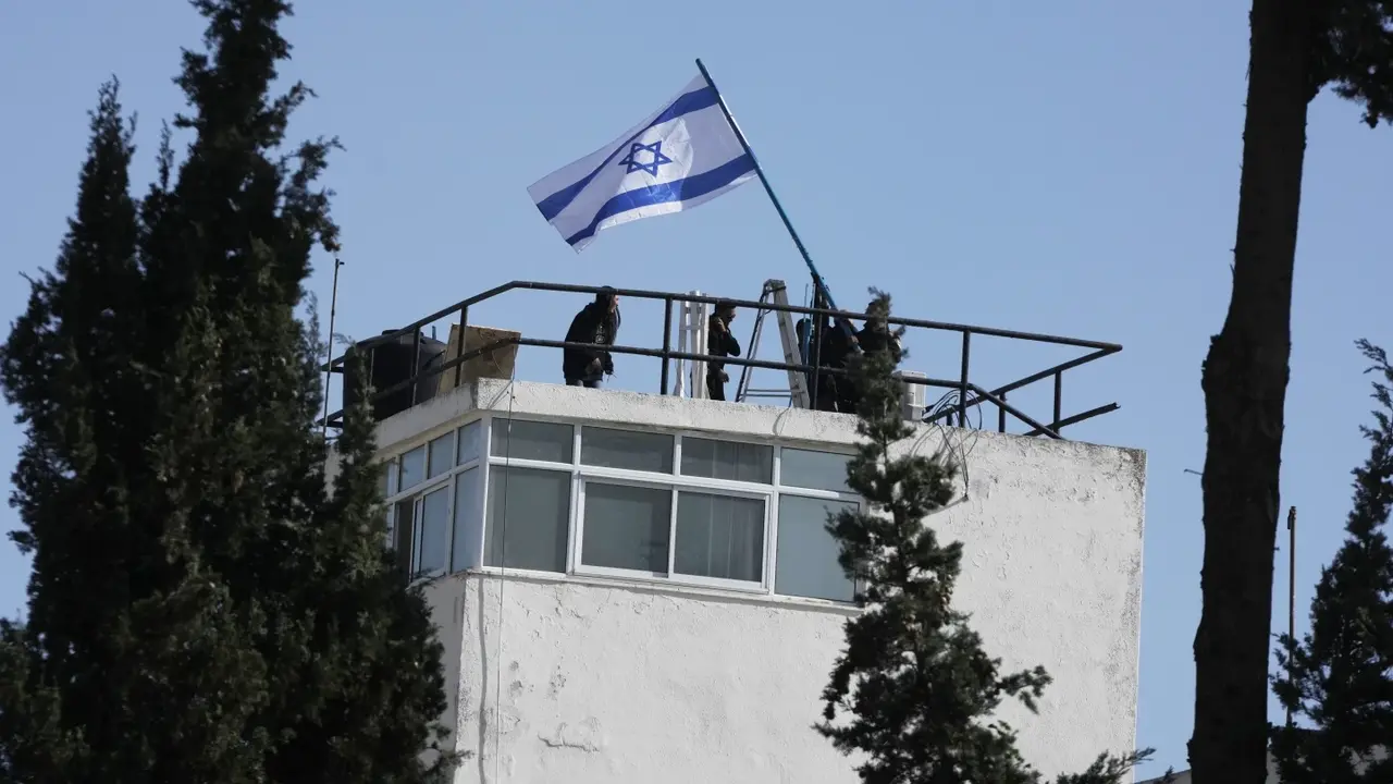 Foto-foto yang diperoleh Associated Press dan staf UNRWA pada Senin (8/12/2025) menunjukkan polisi mengibarkan bendera Israel dan memasuki area kompleks. (Dok. AP Photo/Mahmoud Illean)