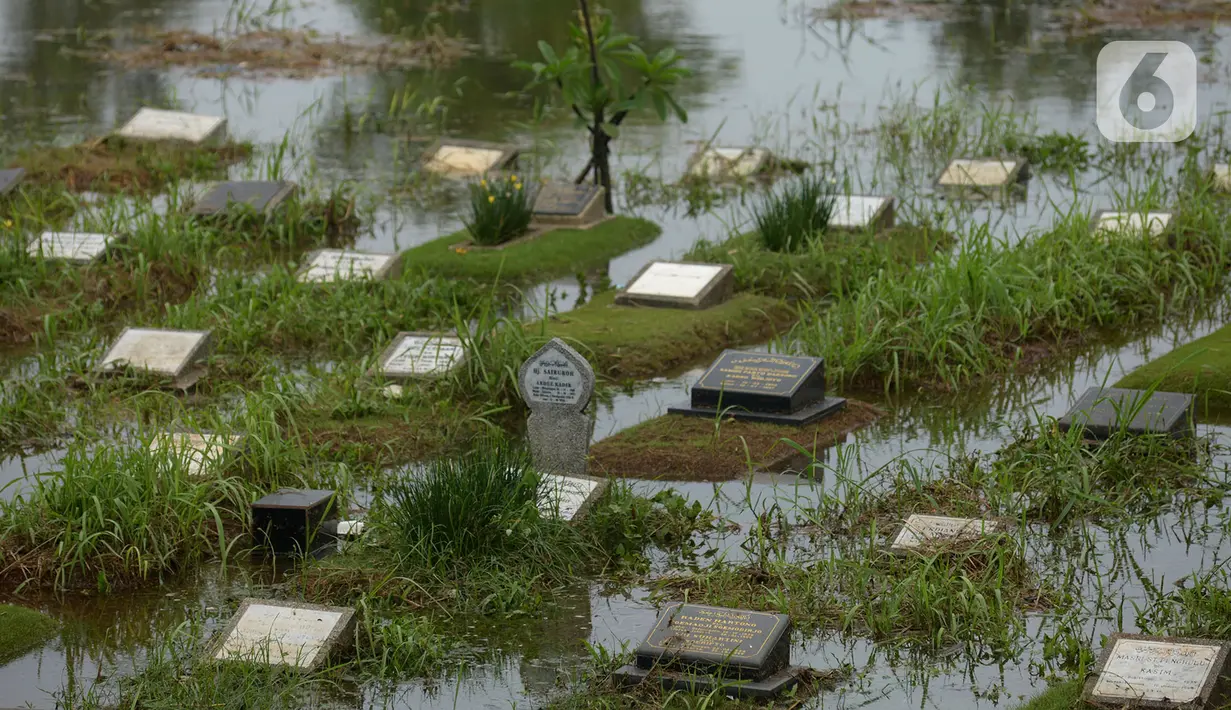 Banjir merendam sejumlah makam di Tempat Pemakaman Umum (TPU) Tanah Kusir, Jakarta, Jumat (3/1/2020). TPU Tanah Kusir terendam banjir setelah Kali Pesanggrahan meluap akibat intensitas hujan  yang tinggi pada Rabu lalu. (merdeka.com/Imam Buhori)