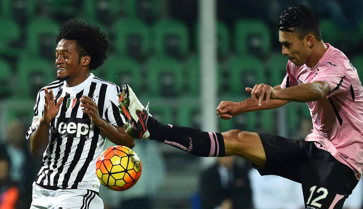 Pemain Juventus, Juan Cuadrado berebut bola dengan pemain Palermo, Giancarlo Gonzalez (kanan)  pada laga lanjutan Liga Italia Serie A  di Stadion Renzo Barbera, Palermo, Senin (30/11/2015) dini hari WIB .  (AFP Photo/Gabriel Bouys)