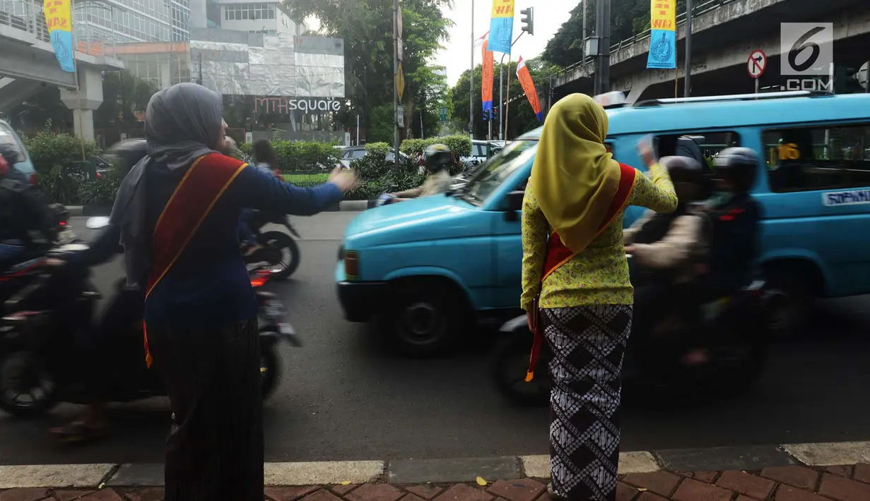 Personel Polisi Wanita (Polwan) Polres Jakarta Timur mengenakan pakaian kebaya saat mengatur arus lalu lintas di Jalan Otista Raya, Jatinegara, Jumat (20/4). Kegiatan tersebut dilakukan dalam rangka memperingati Hari Kartini. (Merdeka.com/Imam Buhori)