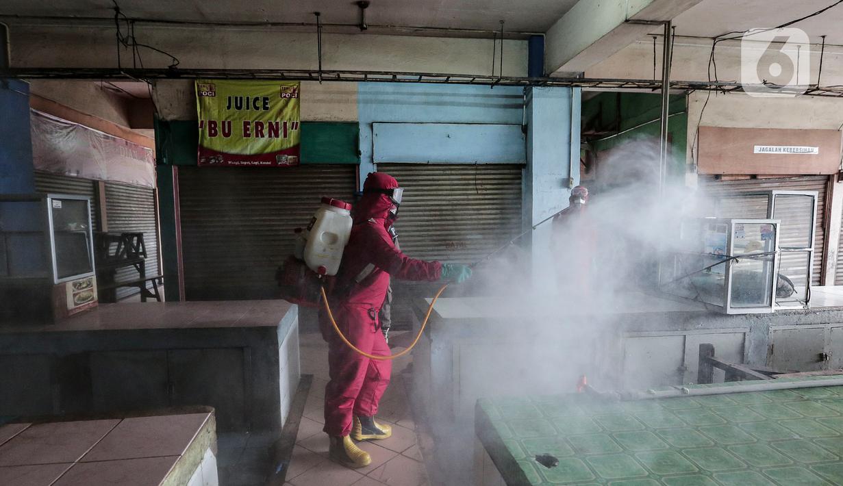 Petugas menyemprotkan Cairan Disinfektan di Pasar Palmerah, Jakarta, Kamis (25/6/2020). Penyemprotan dilakukan guna mencegah dan memutuskan mata rantai penyebaran Covid-19 di Area pasar Palmerah. (Liputan6.com/Johan Tallo)