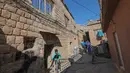 Seorang pekerja kota tiba dengan keledai untuk mengumpulkan sampah rumah tangga di kota Akre, sekitar 500 km sebelah utara Baghdad, Irak, 13 Februari 2021. Keledai dan anak kuda digunakan untuk mengumpulkan sampah di gang-gang yang terlalu sempit dilalui truk atau kendaraan lain. (SAFIN HAMED/AFP)