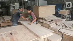 Pekerja memotong papan MDF untuk bahan membuat peti mati Covid-19 di Rawa Mekar Jaya, Serpong, Tangerang Selatan, Kamis (21/01/2021). Peti mati yang dijual dengan harga Rp 1 juta mampu memproduksi 3 peti per hari yang didistribusi di wilayah Jabodetabek. (Liputan6.com/Fery Pradolo)