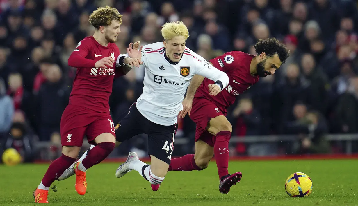 Pemain Liverpool, Mohamed Salah (kanan) dan Harvey Eliott berusaha merebut bola dari pemain Manchester United, Alejandro Garnacho (tengah) pada laga pekan ke-26 Liga Inggris 2022/2023 yang berlangsung di Anfield, Liverpool, Senin (06/03/2023) WIB. (AP Photo/Jon Super)