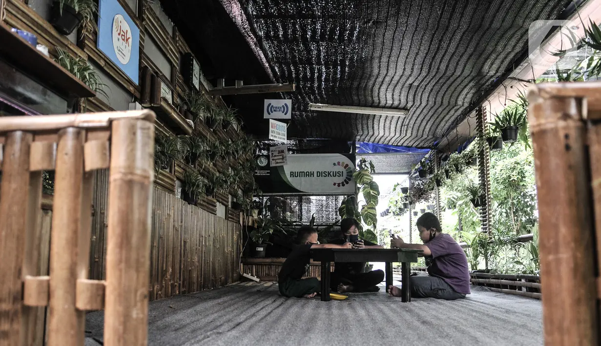 Sejumlah siswa menggunakan jaringan JakWiFi saat mengikuti kegiatan PJJ di Rumah Diskusi RT 007/008 Cipinang Besar Utara, Jakarta, Selasa (8/9/2020). Warga mengeluhkan jaringan JakWiFi di beberapa wilayah karena lemahnya sinyal internet. (merdeka.com/Iqbal S. Nugroho)