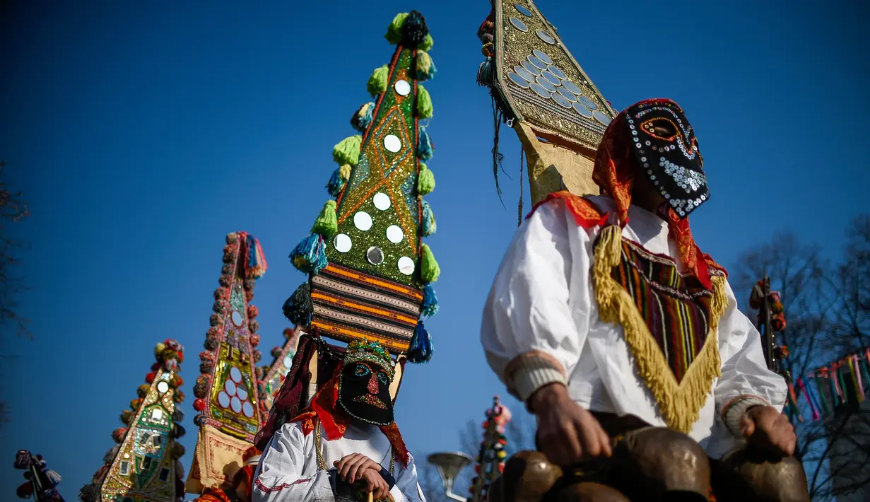 Penari yang dikenal sebagai "Kukeri" mengenakan kostum dan topeng saat tampil dalam Festival Internasional Masquerade Games di Pernik, Bulgaria (28/1). Festival ini digelar untuk mengusir penyakit dan roh jahat. (AFP/Nikolay Doychinov)