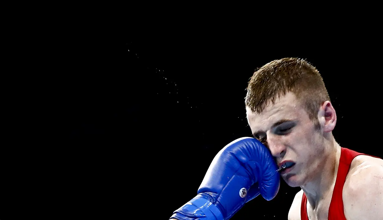 Dean Walsh dari Irlandia terkena pukulan petinju Jerman, Kastriot Sopa saat bertanding di kelas ringan 64kg tinju Pesta Olah Raga Eropa 2015 di Baku, Azerbaijan. (23/6). (REUTERS/Kai Pfaffenbach)