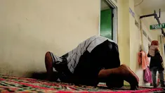 Seorang pedagang laki-laki tampak sholat persis di depan toilet umum di Pasar Blok G, Tanah Abang, Jakarta, (8/7/2014) (Liputan6.com/ Faizal Fanani)