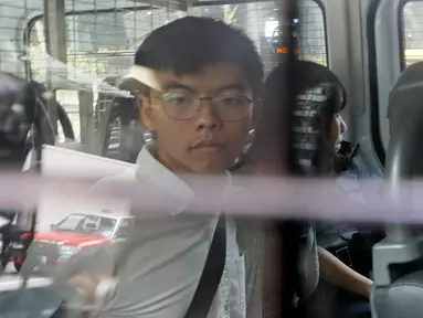 Aktivis pro-demokrasi Joshua Wong (kiri) dan Agnes Chow berada di dalam mobil van polisi di pengadilan distrik di Hong Kong, Jumat (30/8/2019). Polisi Hong Kong menangkap aktivis terkenal Wong dan Chow, anggota inti lainnya dari kelompok pro-demokrasi. (AP Photo/Kin Cheung)