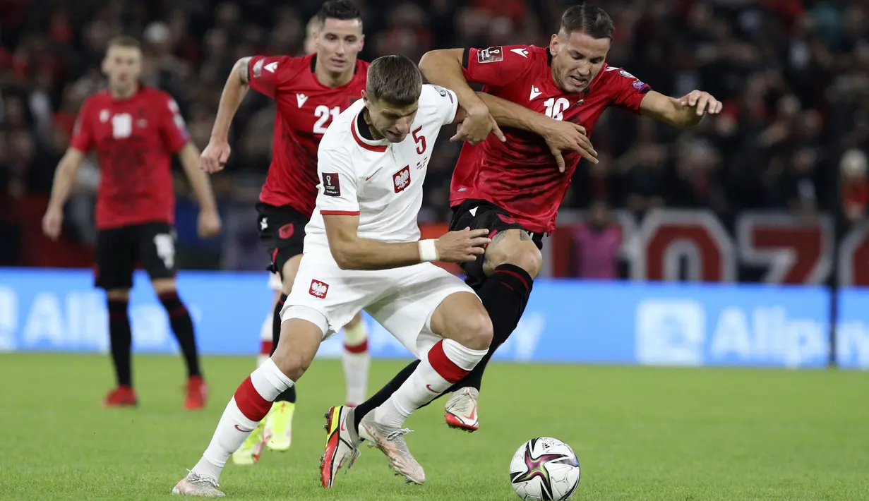 Penyerang Albania Rey Manaj dan bek Polandia Jan Bednarek berebut bola pada lanjutan Grup I Kualifikasi Piala Dunia 2022 Zona Eropa, di Air Albania Stadium, Rabu (13/10/2021) dini hari WIB.  Kemenangan Polandia 1-0 atas Albania diwarnai aksi pelemparan botol oleh suporter. (AP Photo/Franc Zhurda)