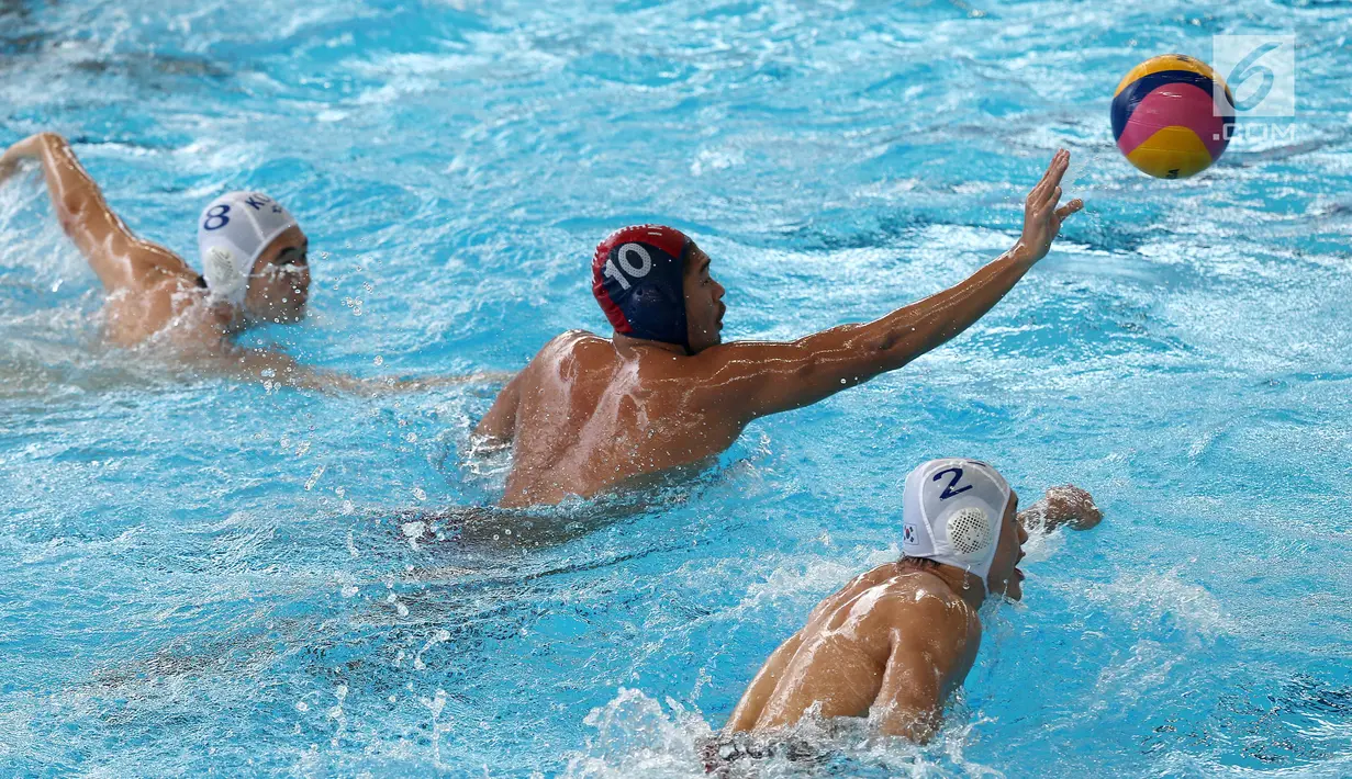 Atlet Polo Air Putra Indonesia, Ridjkie Mulia melempar bola dibayang-bayangi dua atlet Polo Air Putra Korea Selatan pada pertandingan babak semifinal putra peringkat 5 - 8 besar di Akuatik Center, Jakarta, Jumat (31/8).(Liputan6.com/Fery Pradolo)