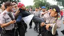 Petugas kepolisian mengamankan mahasiswa yang melakukan unjuk rasa di depan Istana Negara, Kamis (18/5). Kericuhan terjadi karena polisi memaksa untuk membubarkan massa aksi yang dinilai tidak koperatif. (Liputan6.com/Immanuel Antonius)