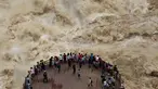 Wisatawan menikmati pemandangan mengerikan derasnya arus sungai Jinsha dari tempat wisata Tiger Leaping Gorge di Diqing, Provinsi Yunnan, China (15/7). (REUTERS / Stringer)