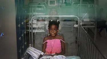 Seorang gadis beristirahat sambil mendengarkan musik di Rumah Sakit Anak Saint Damien Port-au-Prince, Haiti, Minggu (24/10/2021). Dilanda krisis, rumah sakit pediatri utama ibu kota hanya memiliki bahan bakar yang tersisa 3 hari untuk menjalankan ventilator dan peralatan medis. (AP/Matias Delacroix)