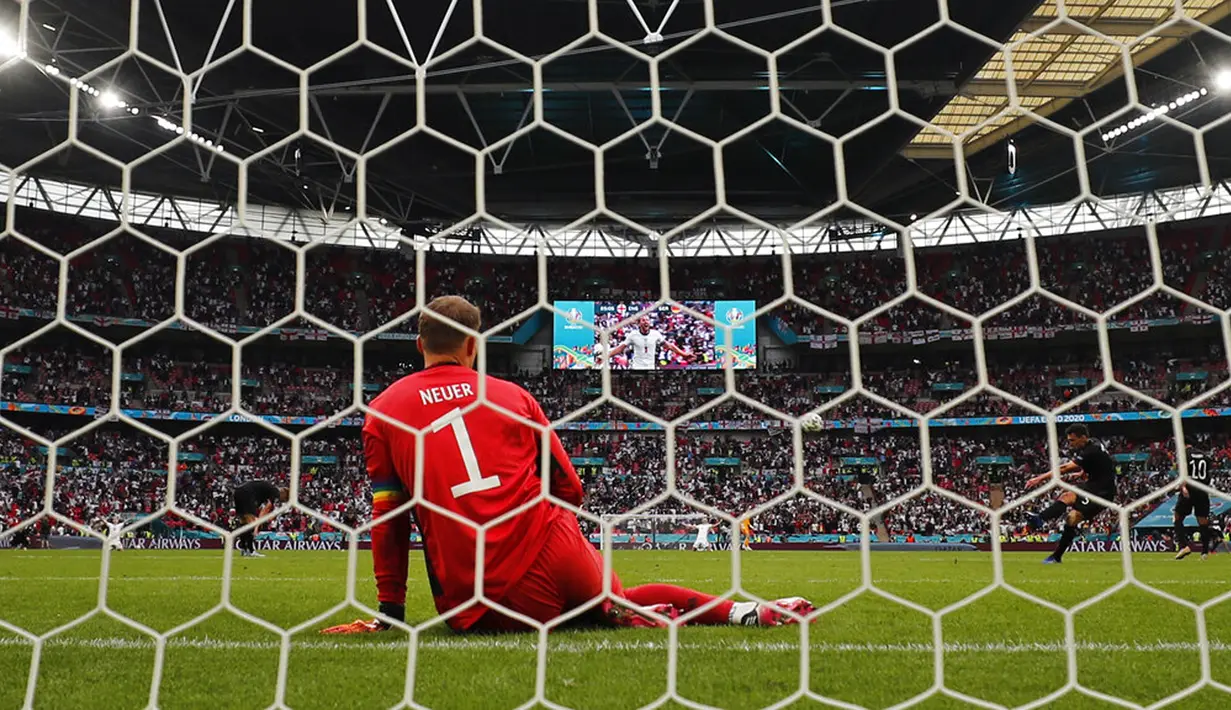 Penjaga gawang Jerman Manuel Neuer duduk di lapangan sementara layar video menunjukkan pemain Inggris Harry Kane melakukan selebrasi usai mencetak gol pada pertandingan babak 16 besar Euro 2020 di Stadion Wembley, London, Inggris, Selasa (29/6/2021). Inggris menang 2-0. (AP Photo/Frank Augstein)
