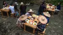 Pelanggan menikmati makan siang di restoran dengan meja di tengah aliran sungai di Kampung Kemensah di pinggiran Kuala Lumpur, Malaysia, Selasa (14/7/2020). Konsep restoran ini cukup unik, memadukan pemandangan air sungai dan pepohonan hijau yang menyegarkan. (Photo by Mohd RASFAN / AFP)