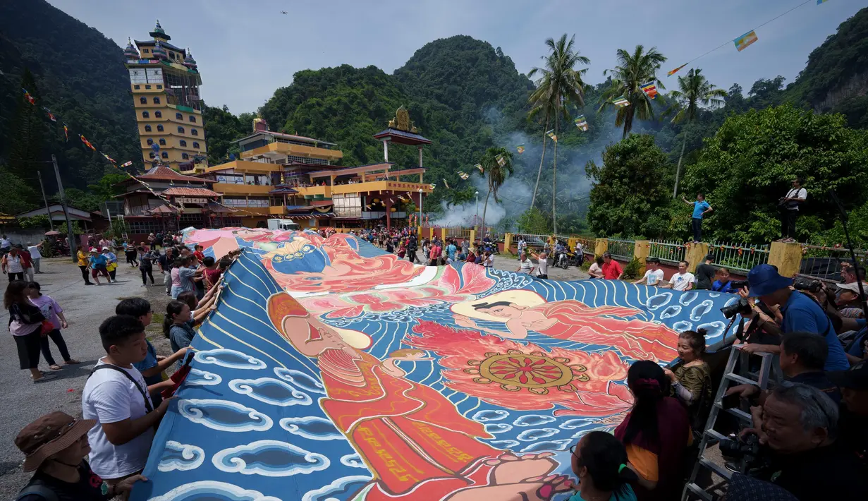 Di Malaysia, umat Budha membentangkan thangka raksasa saat perayaan waisak di Kuil Buddha Tibet di Ipoh. (AP Photo/Vincent Thian)