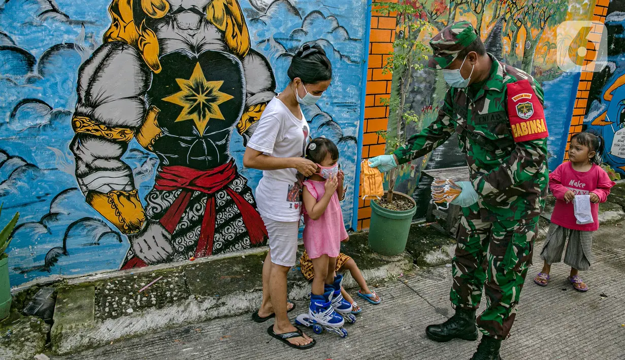 Anggotan TNI membagika masker kepada anak-anak di Sunter Muara, Tanjung Priok, Jakarta, Selasa (9/2/2021). Tujuan kegiatan tersebut agar masyarakat menyadari peran penting penggunaan masker dalam memutus mata rantai penyebaran COVID-19. (Liputan6.com/Faizal Fanani)