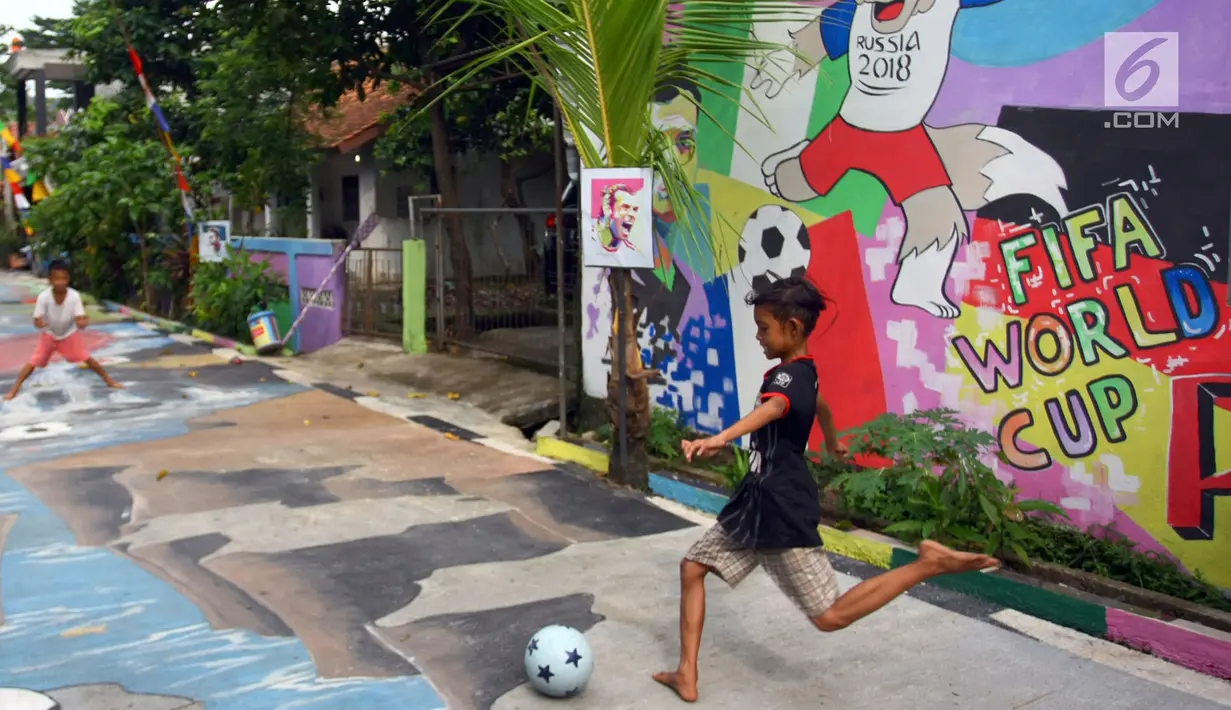 Anak-anak bermain bola di sebuah gang di Kinayungan, Tangsel, Kamis (28/6). Warga di perumahan tersebut menghias lingkungannya menjadi "Kampung Piala Dunia" guna menyemarakan perhelatan sepak bola Piala Dunia 2018 di Rusia. (Merdeka.com/ Arie Basuki)